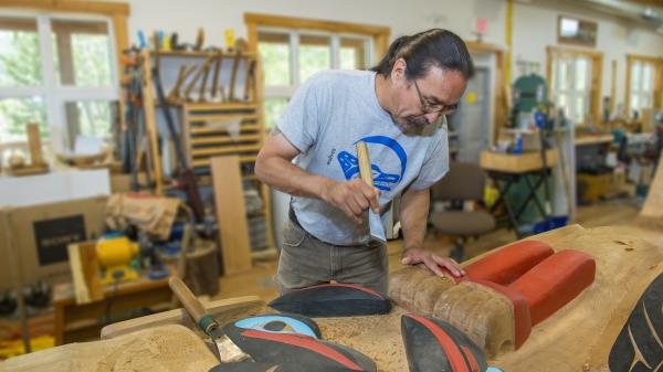 Yukon First Nation artist Keith Wolfe Smarch creating a carving
