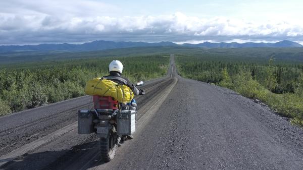 A motorcyclist enjoys a scenic drive down the Dempster Highway