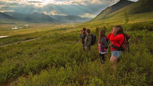 A group of hikers overlook views of Tombstone Territorial Park