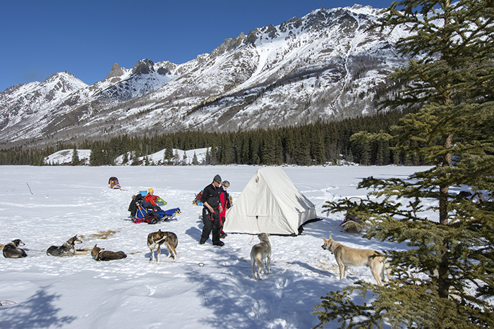 People in front of their winter campsite