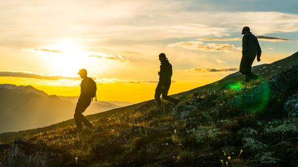 A group of hikers enjoy the Yukon scenery under the midnight sun