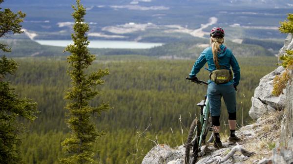 A woman looks out a view from rocky cliff