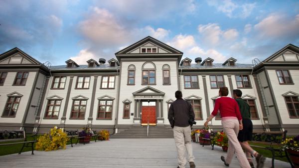 A group of people are walking up to the Dawson City museum