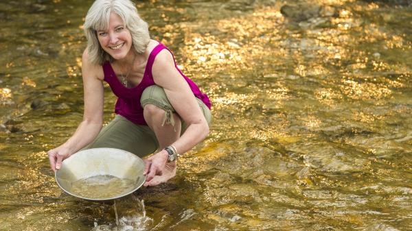 A woman pans for gold in a Yukon creek