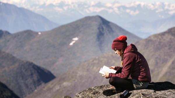 A hiker takes a relaxing break at the top of a mountain