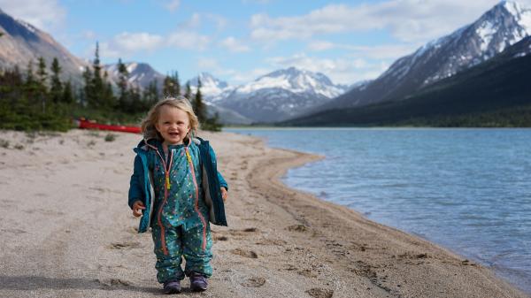 Little girl standing on shore of lake