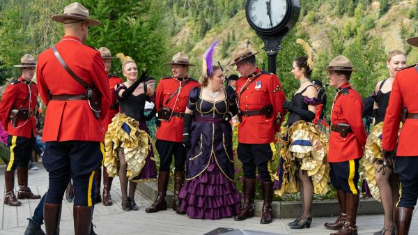 A group of mounties and can can dancers celebrate Discovery Day