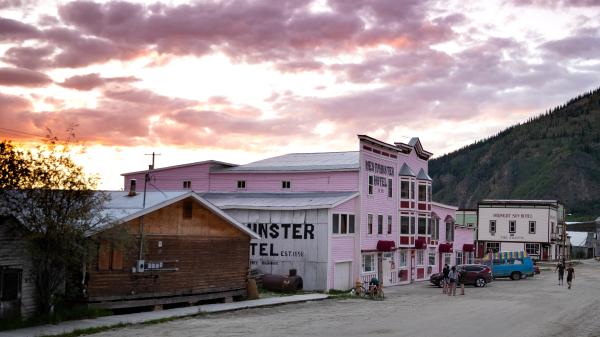 The sun sets over a main street in Dawson City