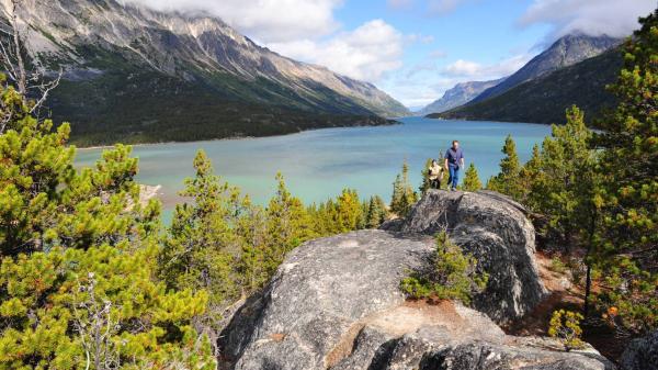Two people climb over large rocks on the Chilkoot trail 