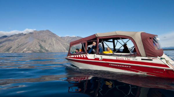 A red power boat on a big lake with a mountain in the background