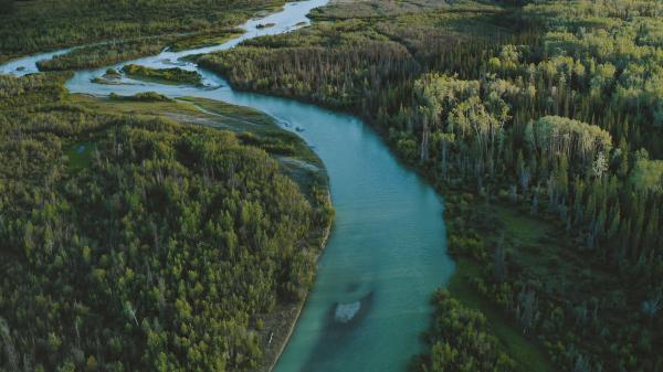 Aerial view of a raft on the Dezadeash River, with the Auriol Range in the distance.