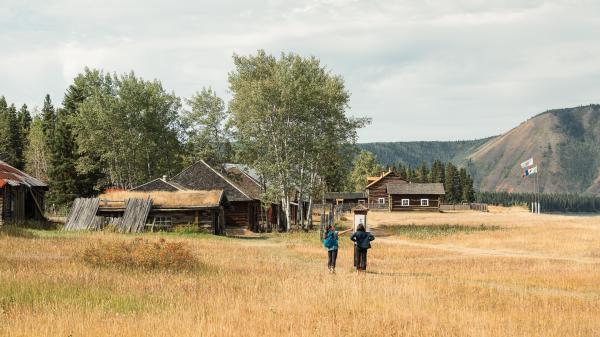 Two people walking at the site of Fort Selkirk