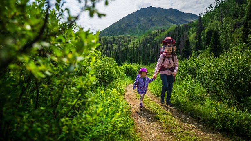 A family hiking on the St. Elias Trail in Kluane National Park and Reserve. The peak behind them is called Tl’eheda, which means “tent” in the Southern Tutchone language.
