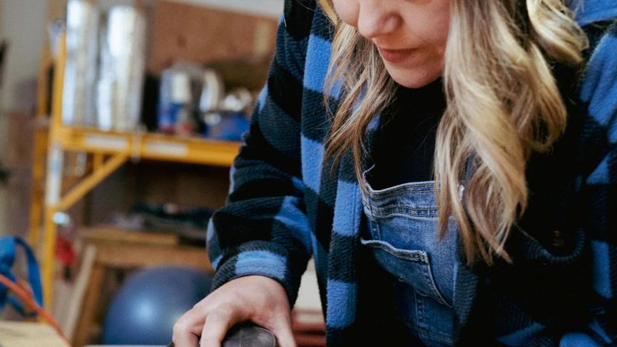 An artist working on a piece of wood