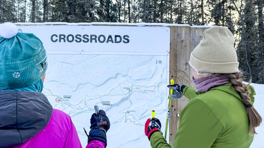 Two cross-country skiers examining the Nordic Centre trail map.
