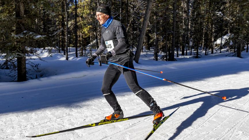 Skier in motion during the Yukon Ski Marathon, gliding along a snowy trail.