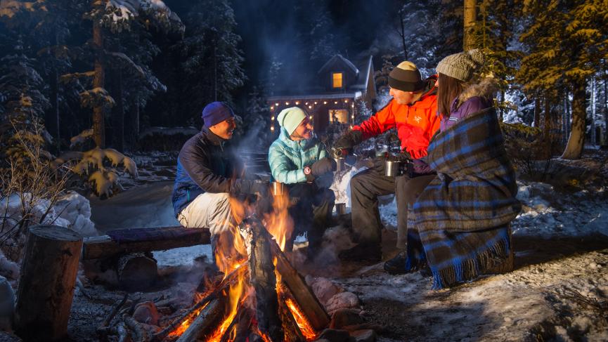 Group gathering around a fire with hot chocolate