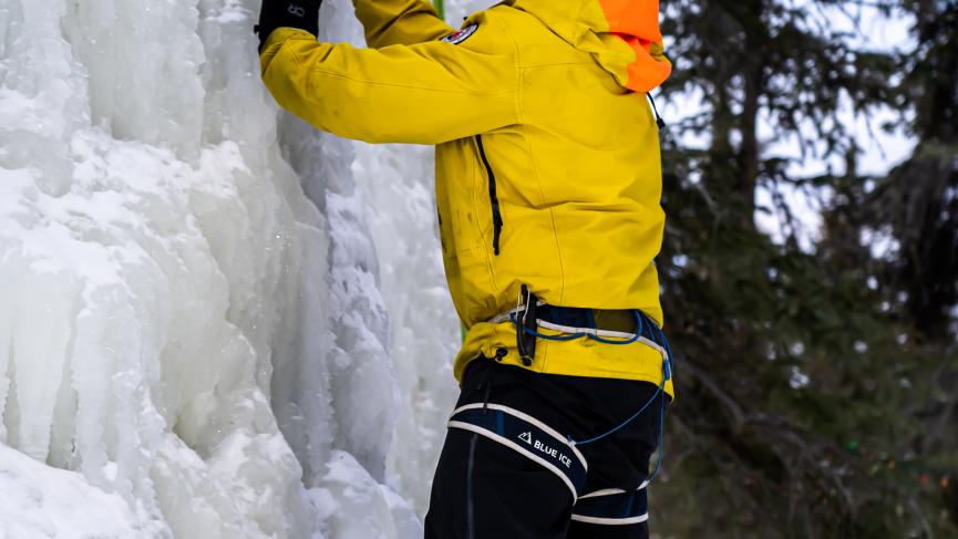 Ice climber with crampons and ice tools