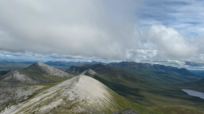 Hiker overlooking Tombstone on summit Pilot Peak