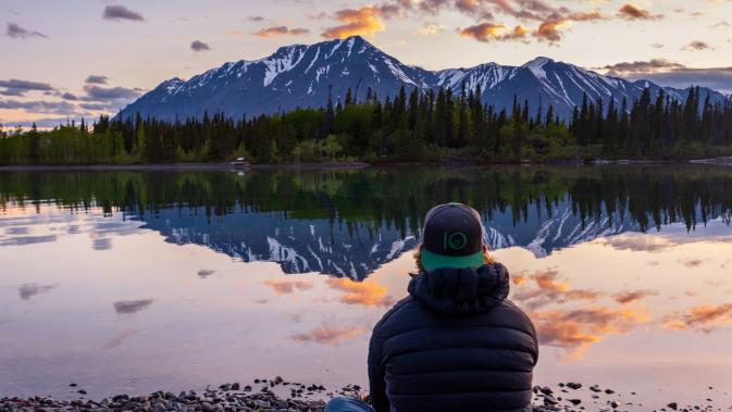 A person enjoying the sunset and the reflection of Mount Worthington on the waters of Mät’àtäna Mǟn (Kathleen Lake).
