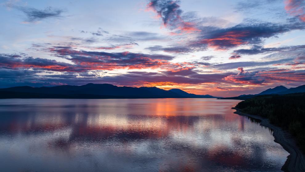 Aerial view from the Alaska Highway across Teslin Lake to Tʼási Hîni (Grayling Creek) at sunset.