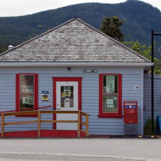 A small blue building with red trim around the doors and windows