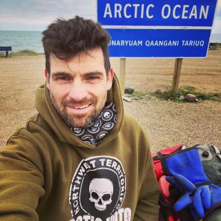 Rider arrives at the end of the Dempster in Tuktoyaktuk