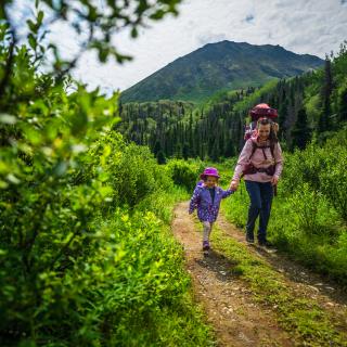 A family hiking on the St. Elias Trail in Kluane National Park and Reserve. The peak behind them is called Tl’eheda, which means “tent” in the Southern Tutchone language.