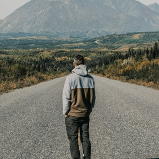 A man standing on the highway looking at a nice view