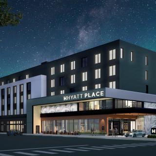 Exterior of the Hyatt Place Whitehorse at night featuring lights on and twinkling stars.