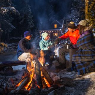 Group gathering around a fire with hot chocolate