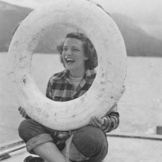 A historical photo of a woman holding a life preserve