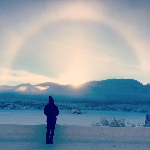 A person stands in front of a sundog