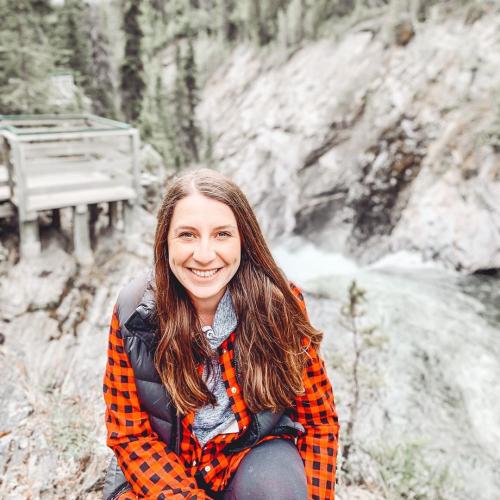 A woman sits in front of a rocky canyon