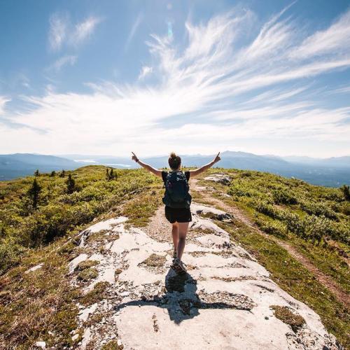 A woman on top of a mountain on a beautiful, clear day