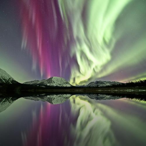 northern lights over mountains and a lake
