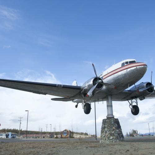 A DC3 weather vein sits under a big blue sky