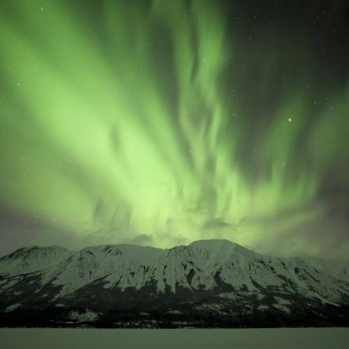 The northern lights flow over Jack Peak and Tutshi Lake along the BC, Yukon border.