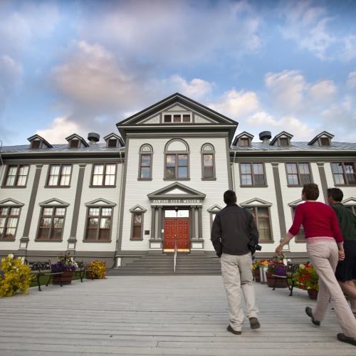 Three people walking into the Dawson City museum