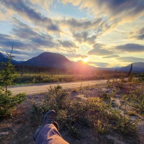 A person relaxes looking out at mountains