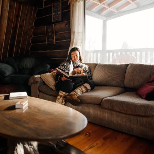 A woman relaxes in a cozy Yukon cabin