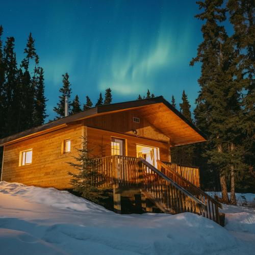 northern lights above a log cabin