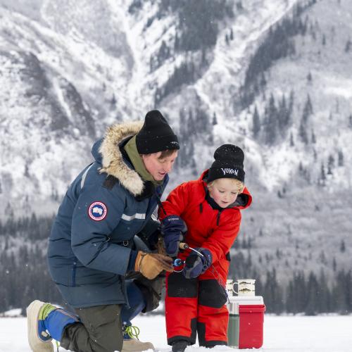 A child Ice Fishing with their Parent