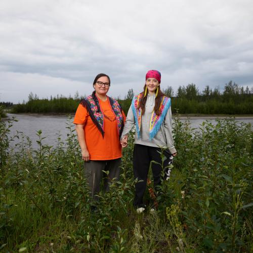A mother and daughter stand on the old town site near Ross River.