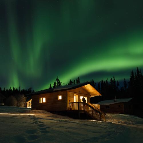 Looking up at northern lights from a cozy cabin.