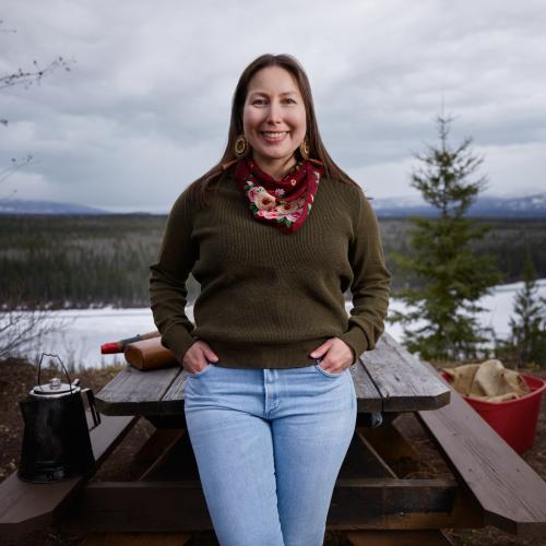 Geri-lee smiling at the camera against a backdrop of a frozen lake and mountains. 