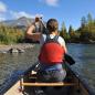 A woman paddles a canoe