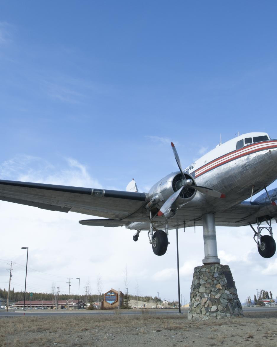 A DC3 weather vein sits under a big blue sky
