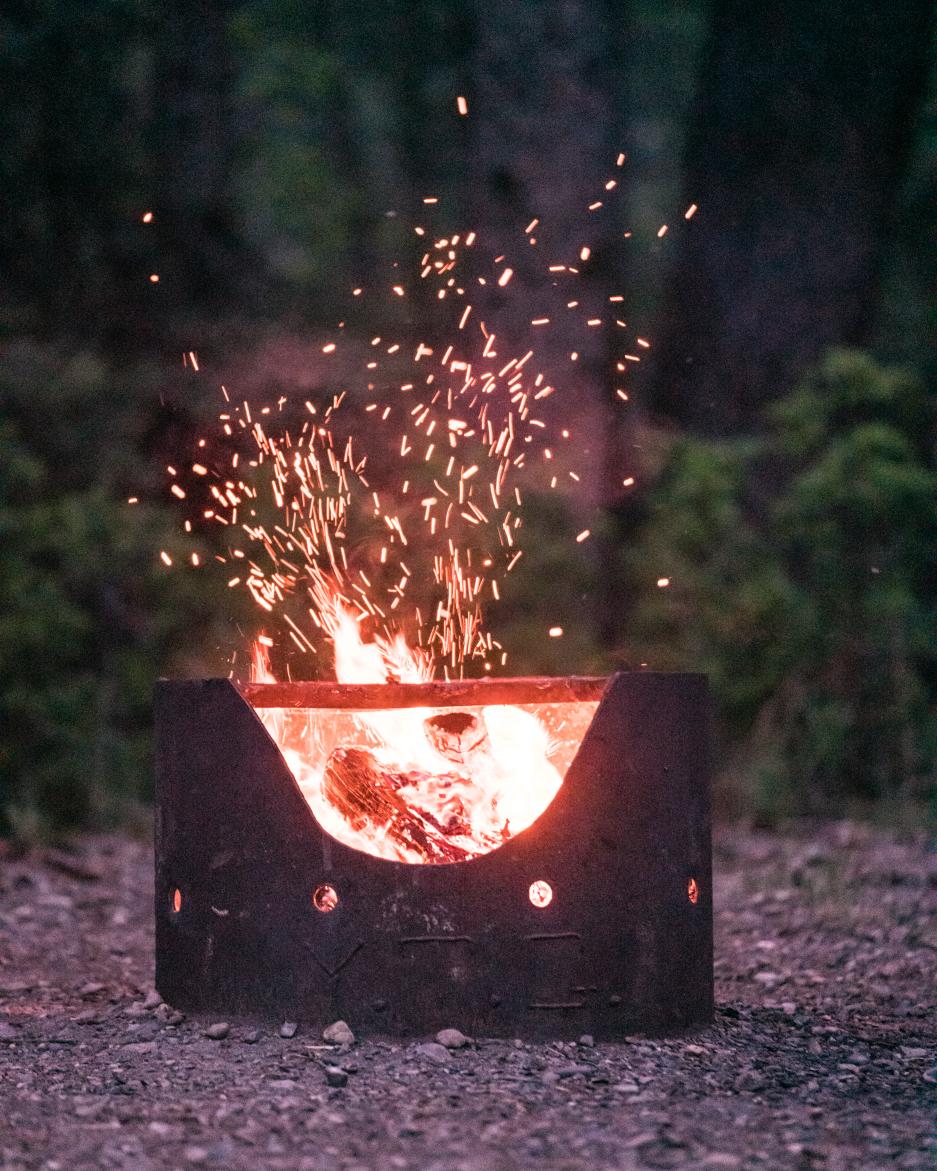 A fire crackles in a campground fire pit