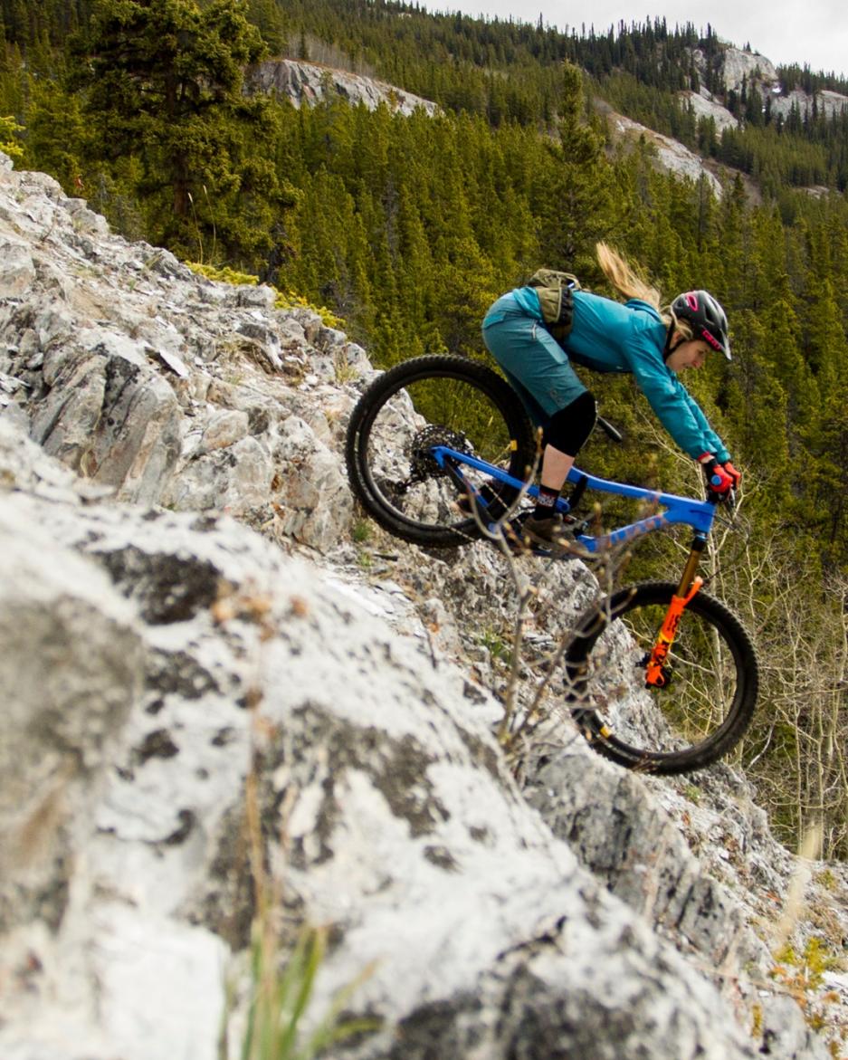 woman biking down a steep rock face